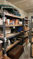 Two metal shelving units next to each other with multiple items on shelves and basement setting.