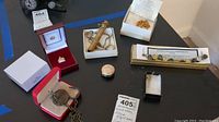 Full overview of assorted items showing bracelet, elephant pendant, pill box, lock, earrings, and crown miniature