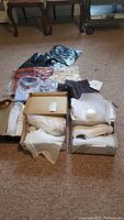 Lot layout showing multiple shirts in original packaging and three pairs of sneakers in boxes