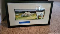 Front view of framed watercolor artwork depicting grazing cattle