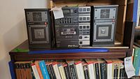 Wide view of stereo components stacked on shelf with speakers on either side