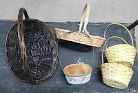 Top view of five assorted baskets on a table showing variety in shapes, sizes and materials.