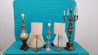 Full front view of the five lamps in the lot against a blue background showing their relative sizes and styles.