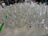 Photo showing six small footed glasses with floral cut patterns.