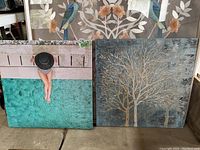 Two square wall art prints: one depicting a woman sitting poolside with turquoise water and another showing a detailed tree in muted grey-blue tones.