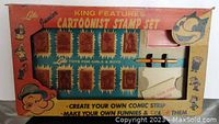Photo of the original box with stamps displayed and colorful cartoon graphics including Popeye and Felix