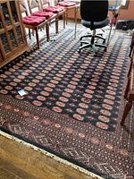 Full view of rug laid on hardwood floor under chairs and office chair