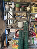 Photo showing one metal shelving unit approximately 3ft by 6ft with various garden pots and accessories on and around it, used condition.
