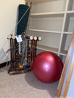 Whole lot showing croquet set, yoga ball and rolled hammock leaning against corner wall