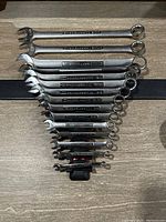 Top view of the 15 Craftsman combination wrenches laid out showing open-end and box-end.