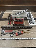 Full overview of all hand tools including wrenches, sockets, ratchets, pliers, hex keys laid out on table.