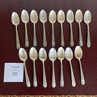 Full set of 16 silver plated commemorative spoons, laid out to show bowls and handles