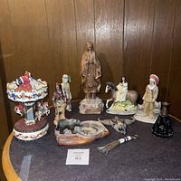 Full view of various Native American figurines along with carousel music box and animal figurines arranged on table.