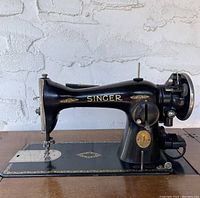 Left side view showing overall machine body, gold details and 'SINGER' script.