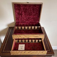 Wood storage chest open showing velvet lining and vertical slots for flatware organization.