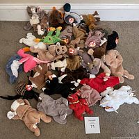 Photo of 31 assorted Ty Beanie Babies plush toys arranged on carpet floor.