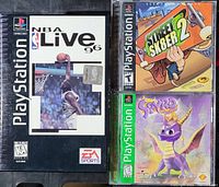 Three Sony PlayStation game cases NBA Live 96, Street Sk8er 2, Spyro the Dragon side by side showing front cover art.
