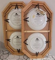 Back of two wooden framed plaques showing mounting hardware and certificate text on plate backs