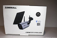 Box front showing Zumimall branding and solar panel with security camera image.