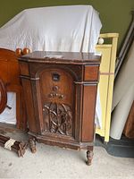 Front view of Philco antique wooden cabinet radio showing ornate carved front panel with control knobs and grille.