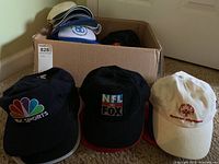 Three baseball hats displayed in front: NBC Sports, NFL on Fox, and Special Olympics.