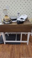 Table shown with attached leaves closed, items on top (kitchen appliances) not included.