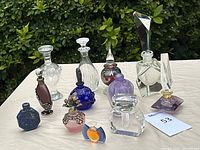Group shot of all eleven bottles on white surface with greenery background