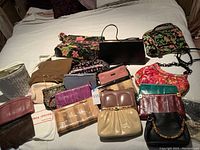 Wide view of all handbags and dust bags laid out on bed