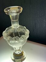 Front and side view of Lalique Martin perfume bottle showing frosted glass floral ring and clear glass body.