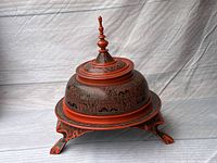 Photo of large lacquered Asian bowl with lid on matching pedestal stand against a neutral backdrop.