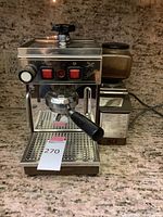 Front view of stainless steel espresso machine and attached grinder on countertop