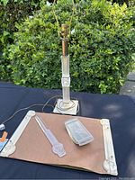 Full view of lamp base, letter opener, pen tray and blotter feet arranged on table