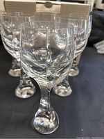 Six Baccarat wine glasses arranged in front of original box