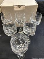 Six glasses arranged in front of original box showing full set