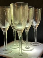 Six flutes grouped on illuminated surface showing overall design and condition