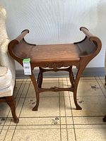 Full view of the wooden curved side table showing its shape and legs