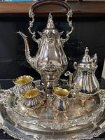 Full view of service on trays showing urn, tea pot, jugs and bowls