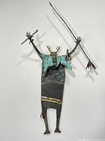 Full front view of bronze shaman sculpture mounted on wall