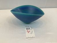 Photo of blue glazed ceramic art bowl with pointed shape and smooth glossy finish, tagged with lot number.