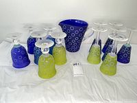 Full set of colored EM art glass with one pitcher and 12 glasses showing color variety and design.
