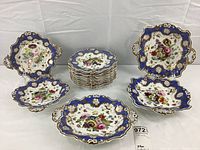 Full lot arrangement showing 12 stacked dessert plates in center and 5 serving dishes around