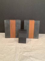 Front view of two rectangular slate and wood bookends and a smaller rectangular slate block arranged in a row