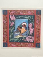 Close-up of the Mandarin bird etching showing vivid colors and detailed floral border.