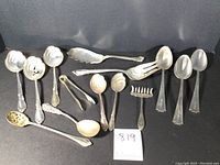 Assortment of all 16 sterling serving pieces laid out