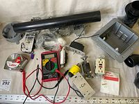 Lot contents showing plastic pipe, junction box, electrical components, measuring tape, and multimeter on white background