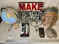 Full view of assorted home decor items including globe, masks, candlestick, wine saver, and sign.