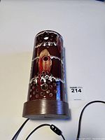 Full view of the unlit ceramic lamp with teak base showing the glossy brown surface, white drip accents, and circular holes.