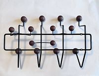 Top view photo of the wall hanger flat laid showing all hooks with walnut brown balls and black metal frame