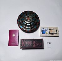 Front view of vintage flying saucer shaped tin, Kropp Razor box, Snap card game box, and Sun Insurance booklet