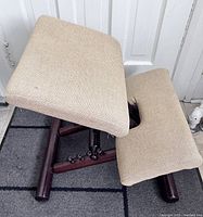Full view of vintage Peter Opsvik kneeling chair with beige fabric cushions and dark wooden frame.